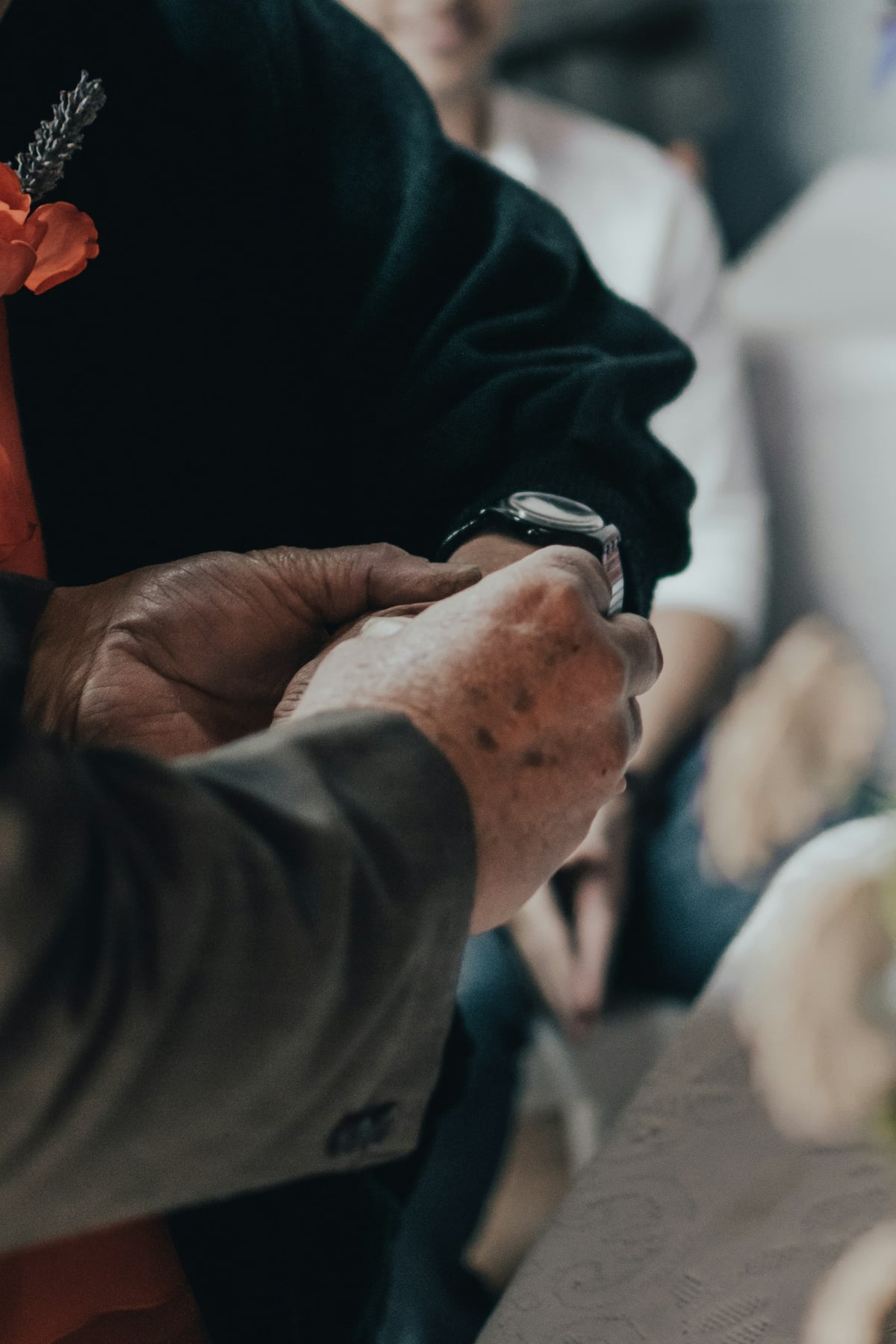 Close-up of an older person's wrist wearing an SOS wristband in a home setting