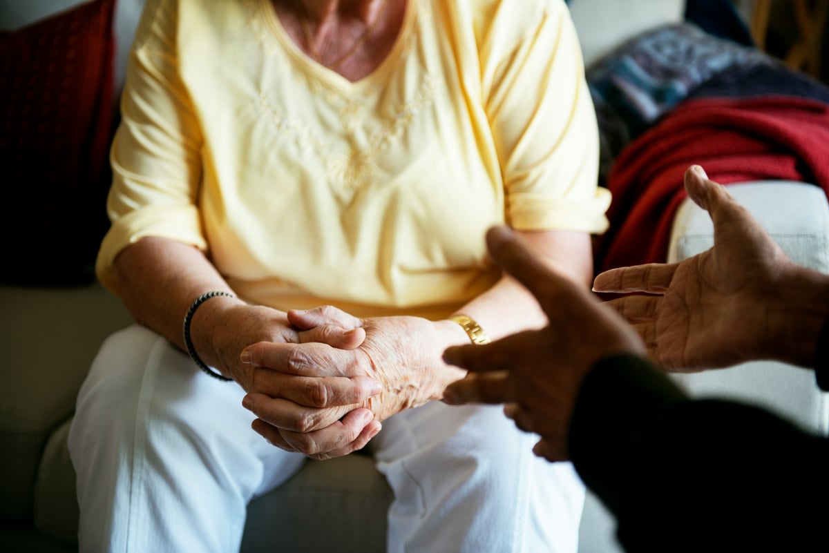 An older person gestures during a conversation, highlighting dignity and independence